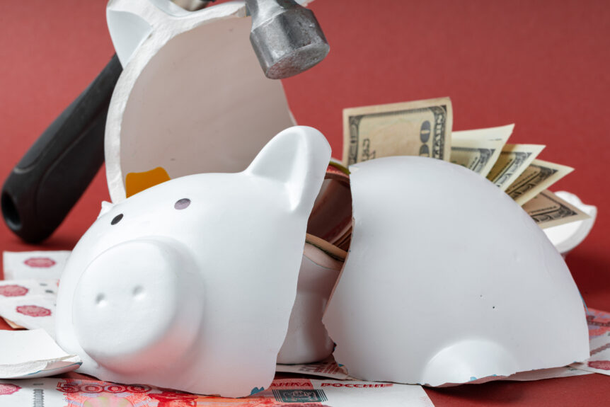 A person looking concerned while holding a shattered piggy bank, symbolizing the hidden costs of tax deferral.