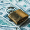 Metallic padlock on dollar banknotes